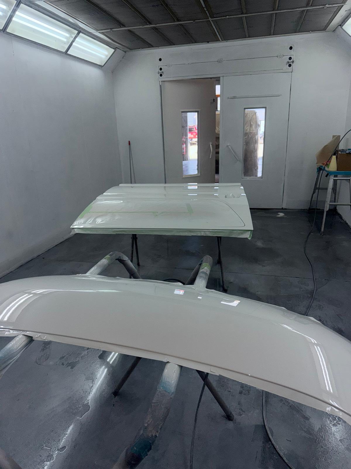 Professional spray booth — cream panels hanging and drying